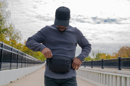 EDC Sling Bag & Waist Pack  in Black worn around waist.