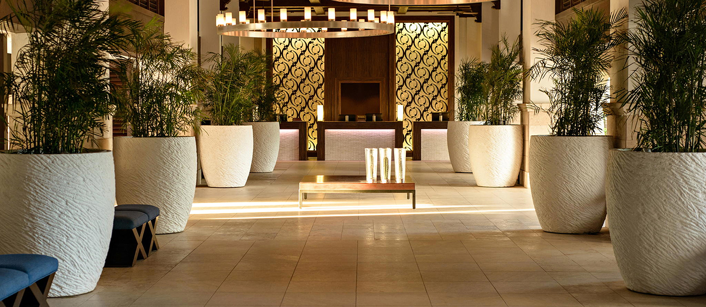 Lined up up to make a dramatic entrance, the Roman Pond Planters in chalk are a key design element of this hotel lobby