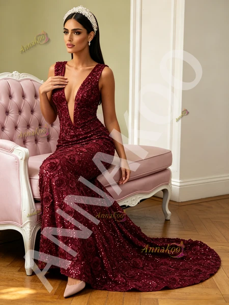 Close-up of the delicate sequin flower embellishments adorning the bodice and skirt of a burgundy deep V-neck prom dress.

