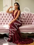 Burgundy trumpet mermaid prom dress with a deep V-neckline, a fitted silhouette, and intricate sequin flower embellishments.