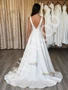 Back view of a simple satin A-line wedding dress showing the elegant train.