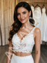 Close-up of the intricate lace appliqués on the V-neck crop top of a two-piece bridal gown.