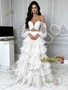 Full-length look at the bohemian-style white off the shoulder ball gown with beaded top and layered tulle.
