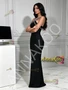 Side profile of sleek black satin backless halter gown with subtle shine and long sheath skirt