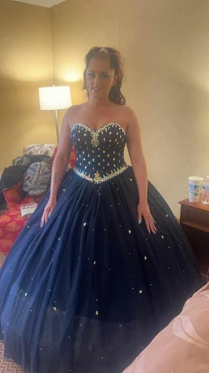 Bride fully dressed and laced into her navy blue wedding gown in a hotel suite