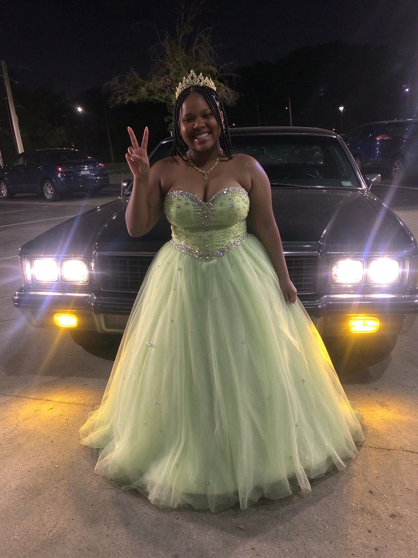 Sparkling beaded bodice and full tulle ball gown in a confident evening pose
