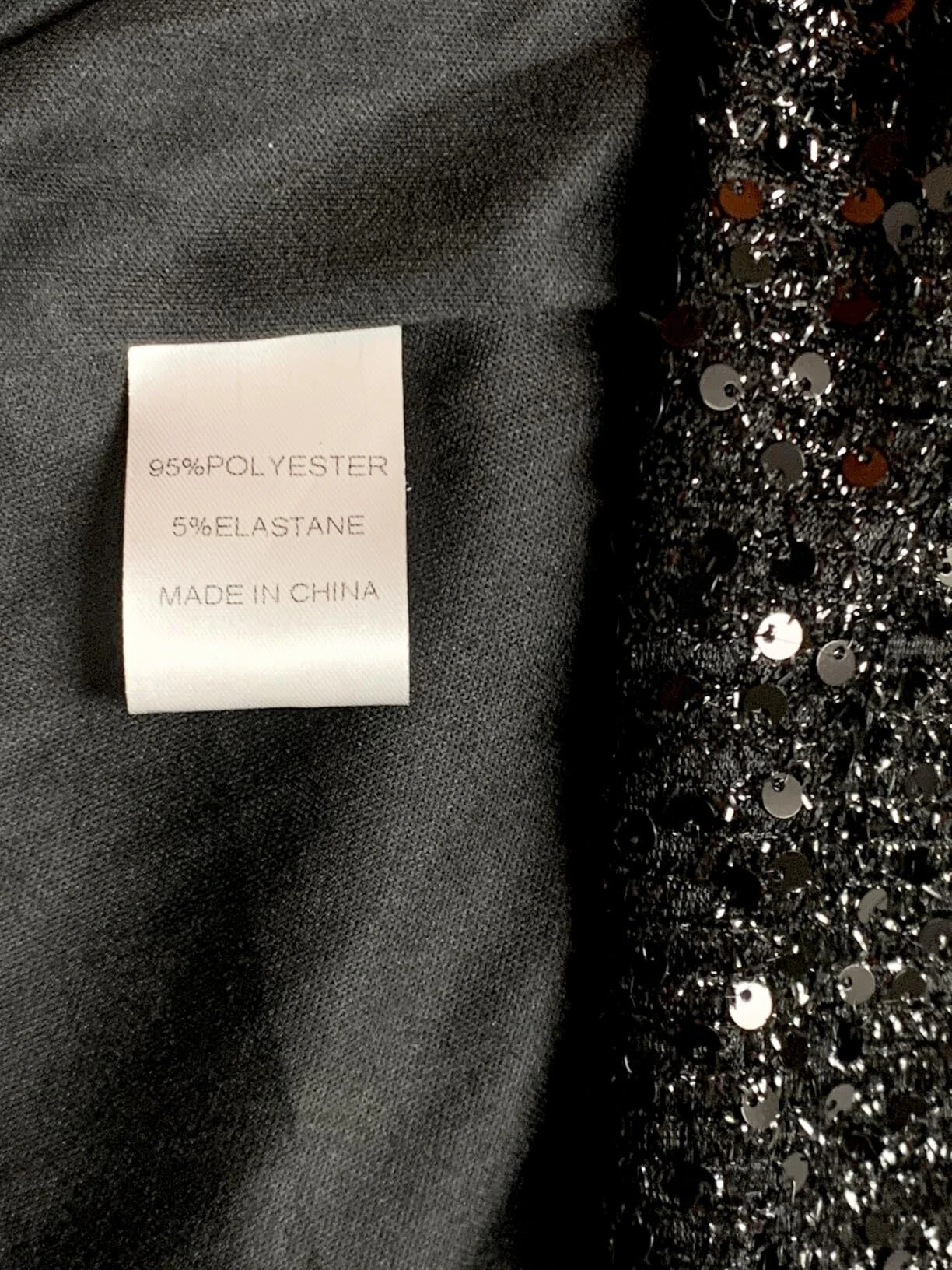 Close-up of the fabric label on a black sequin prom dress