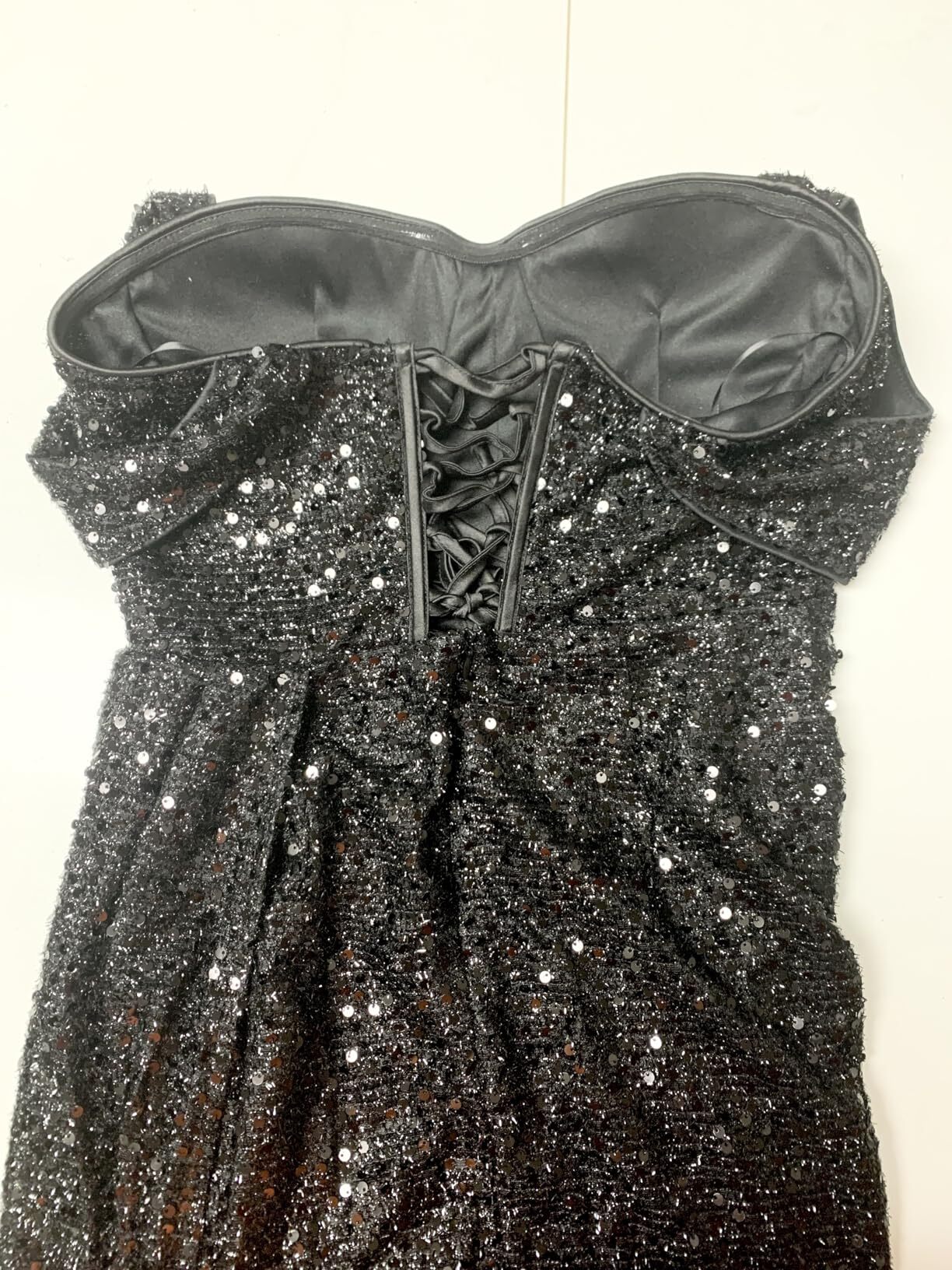 Black sequin prom dress showing the fitted mermaid silhouette and lace-up back