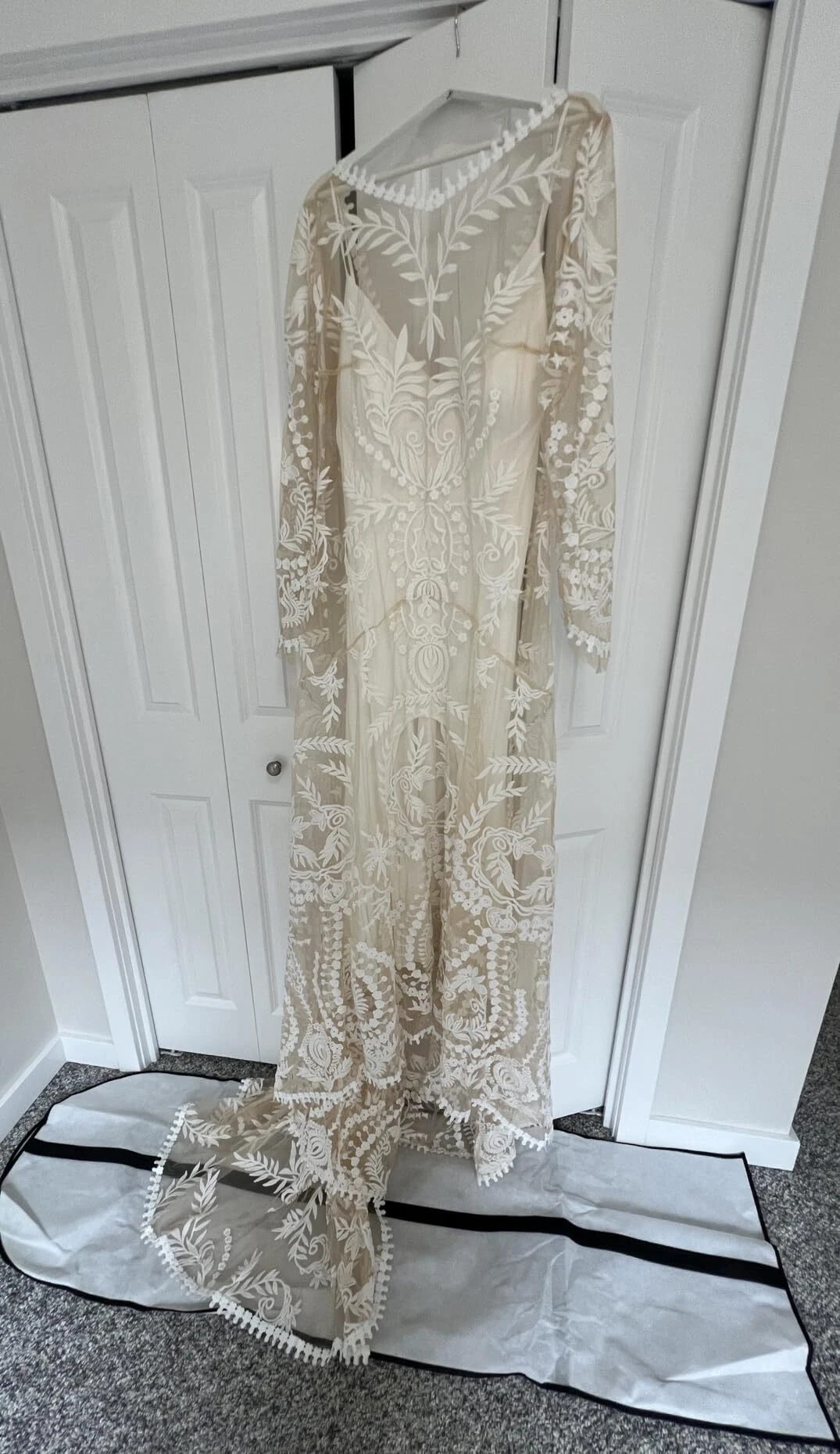 Bohemian lace wedding dress hanging before Texas ranch wedding