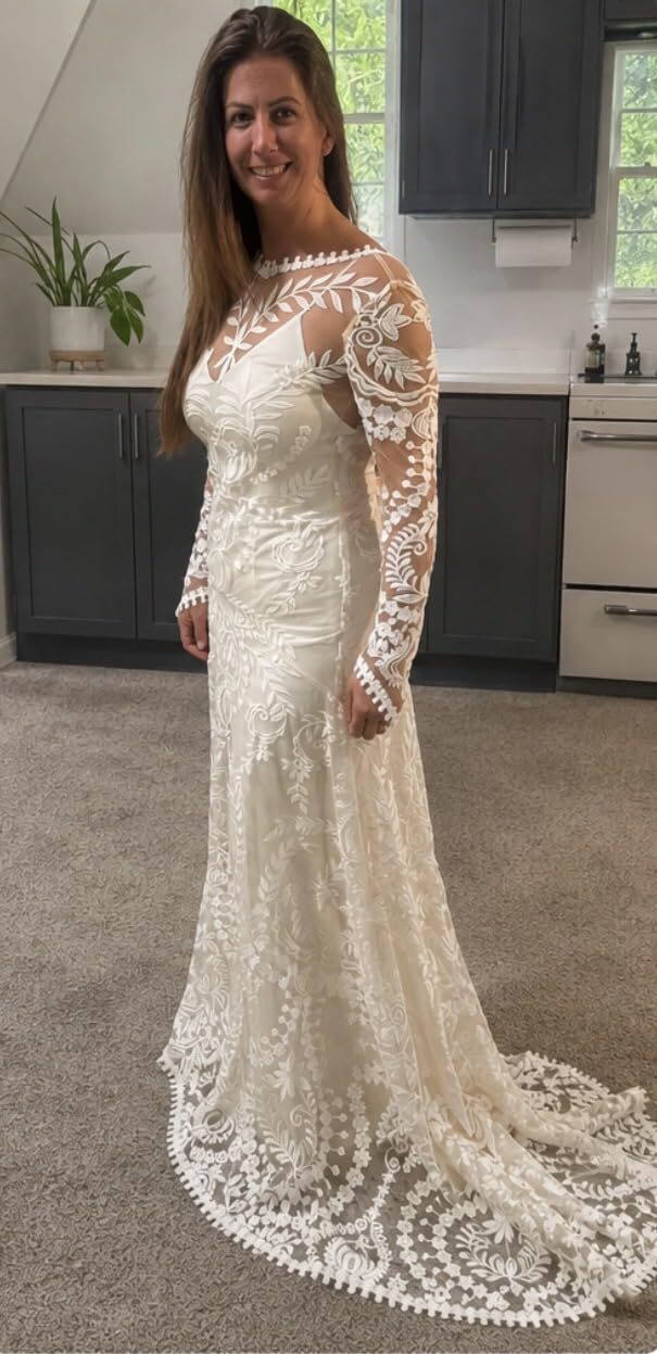Bride trying on a boho lace wedding dress at home before the wedding
