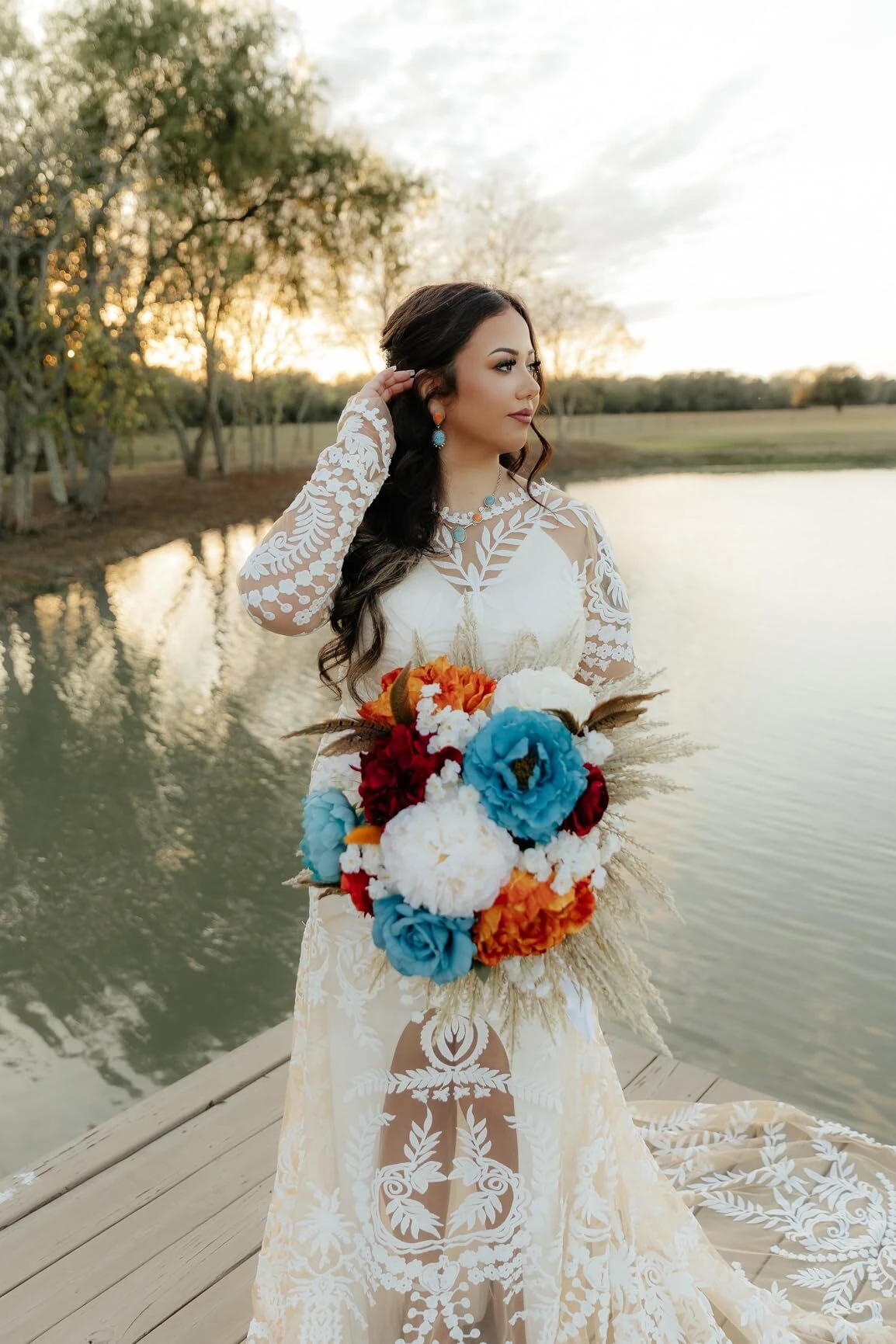 Bride holding colorful bouquet wearing detailed botanical lace wedding dress