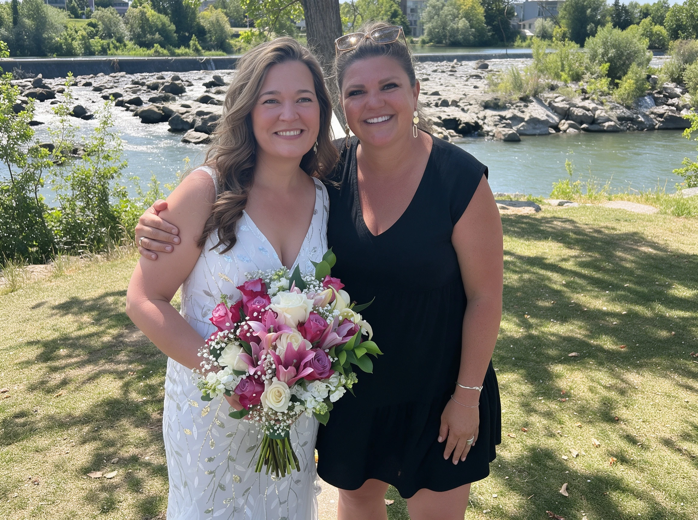 Bright candid photo of the bride and her friend laughing by the river