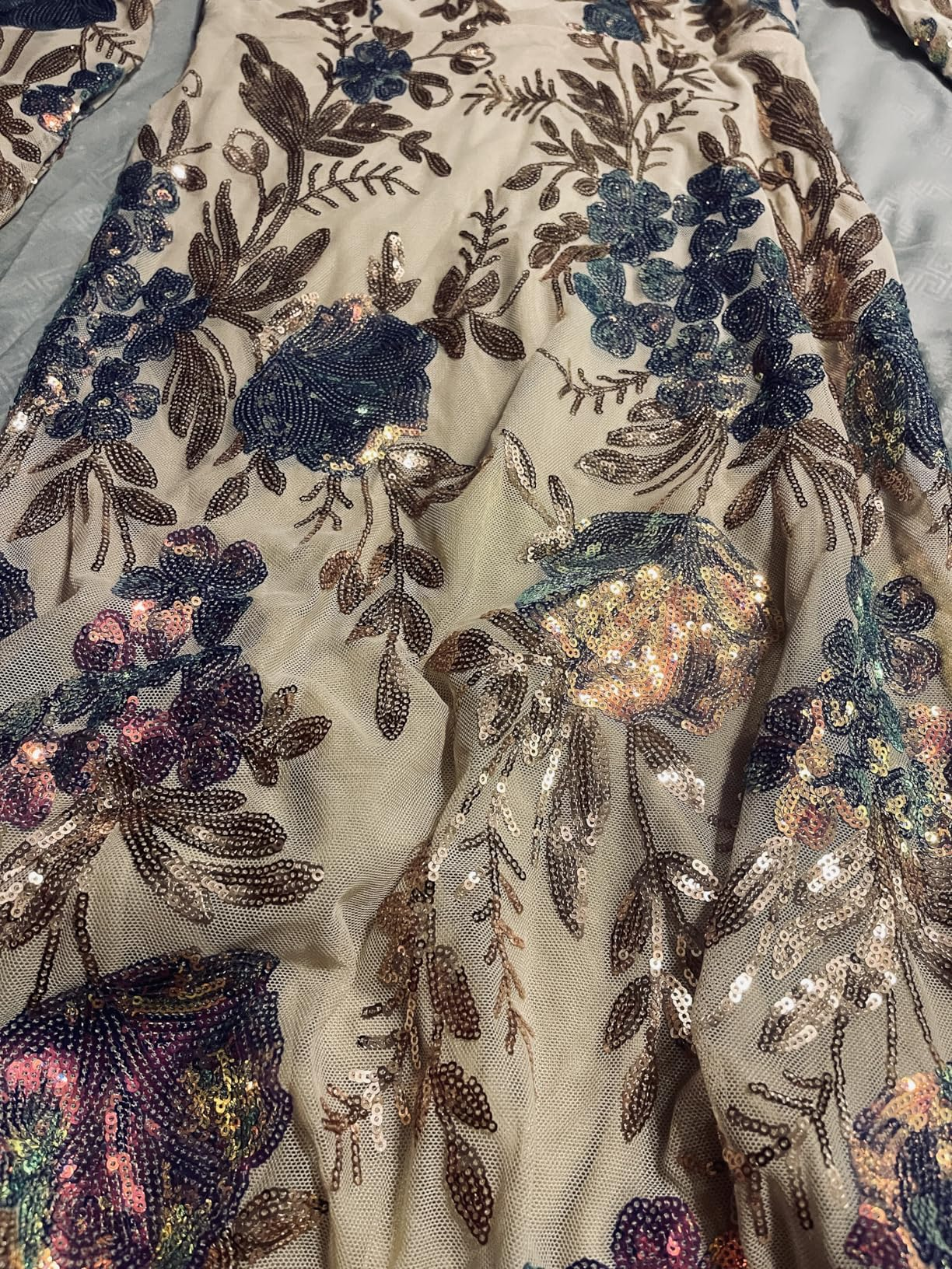 Close-up of floral sequin details on a champagne beige evening gown