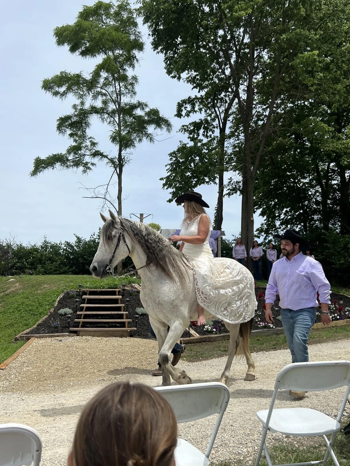Bride wearing a country western wedding dress on horseback during a wedding ceremony