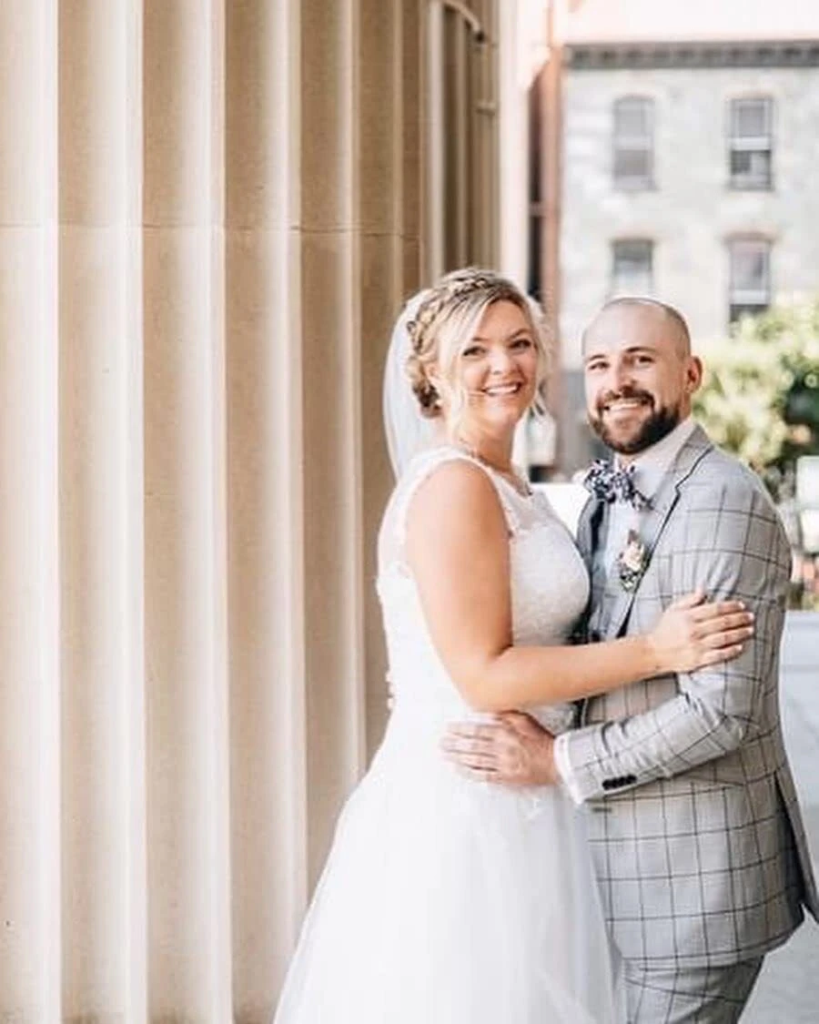 Embracing my husband in my short lace wedding dress after the ceremony