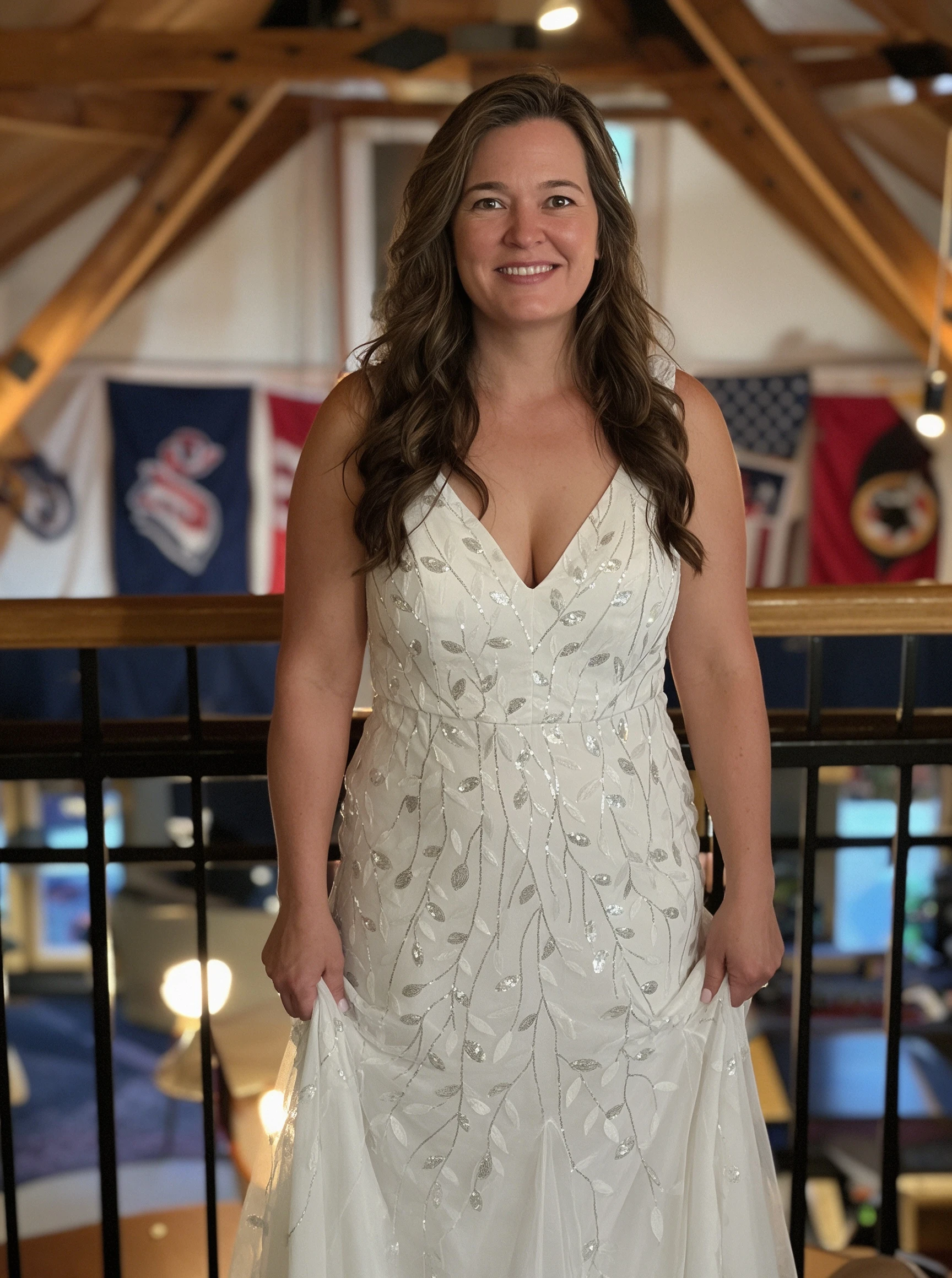 Full-body shot of the bride in her beaded gown inside the rustic barn reception