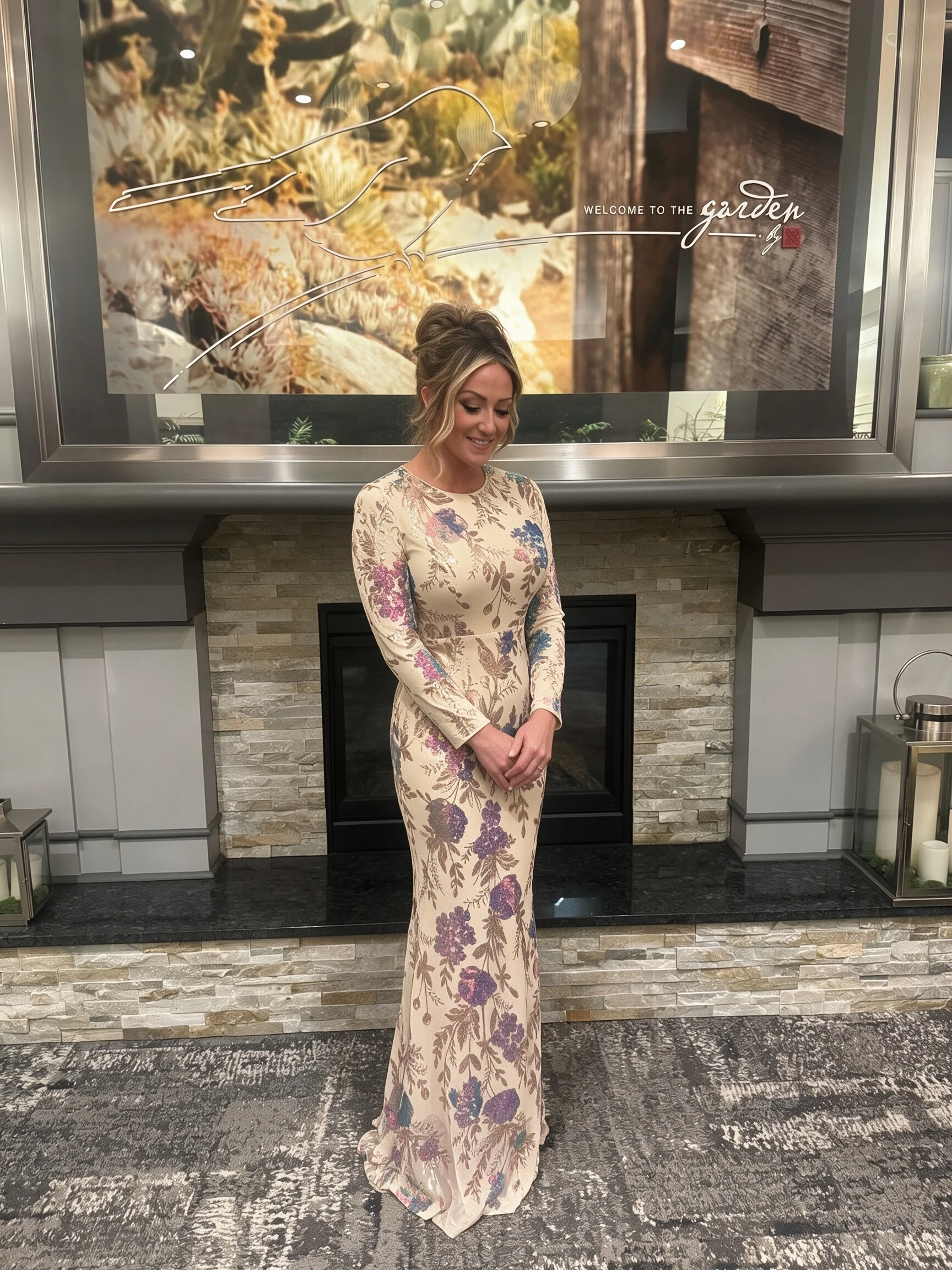 Full-length champagne floral formal gown photographed beside a hotel fireplace