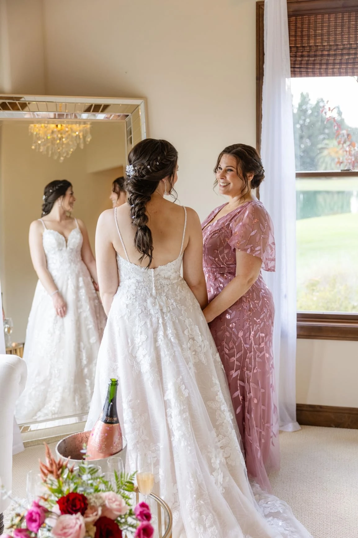 Mother and daughter getting ready together before an outdoor wedding