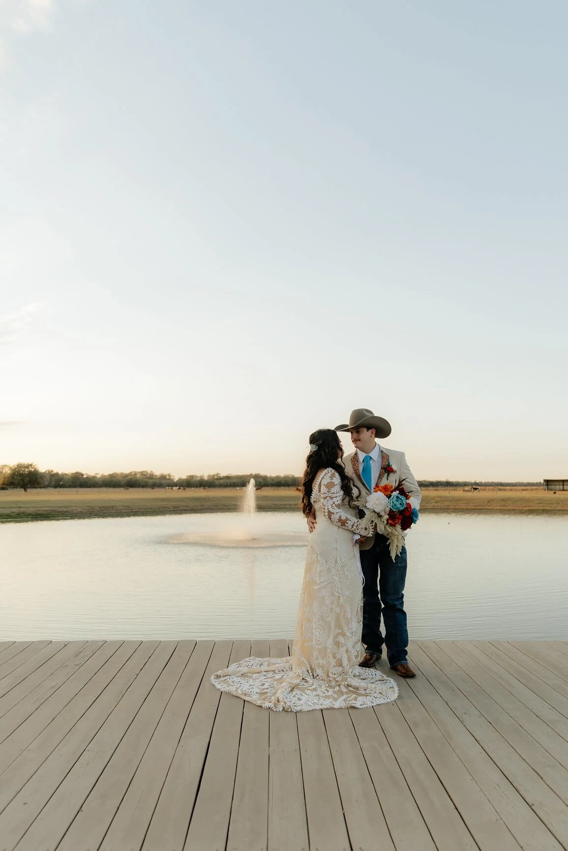 Bride and groom during golden hour wearing boho lace wedding dress