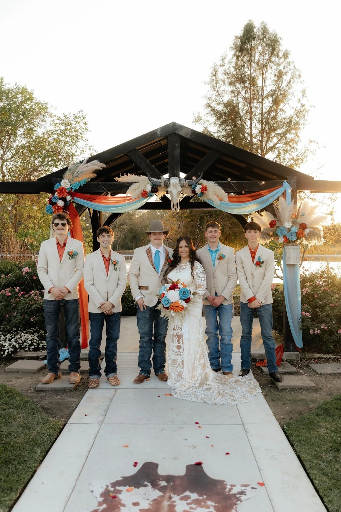 Groomsmen group photo with bride in boho lace wedding dress
