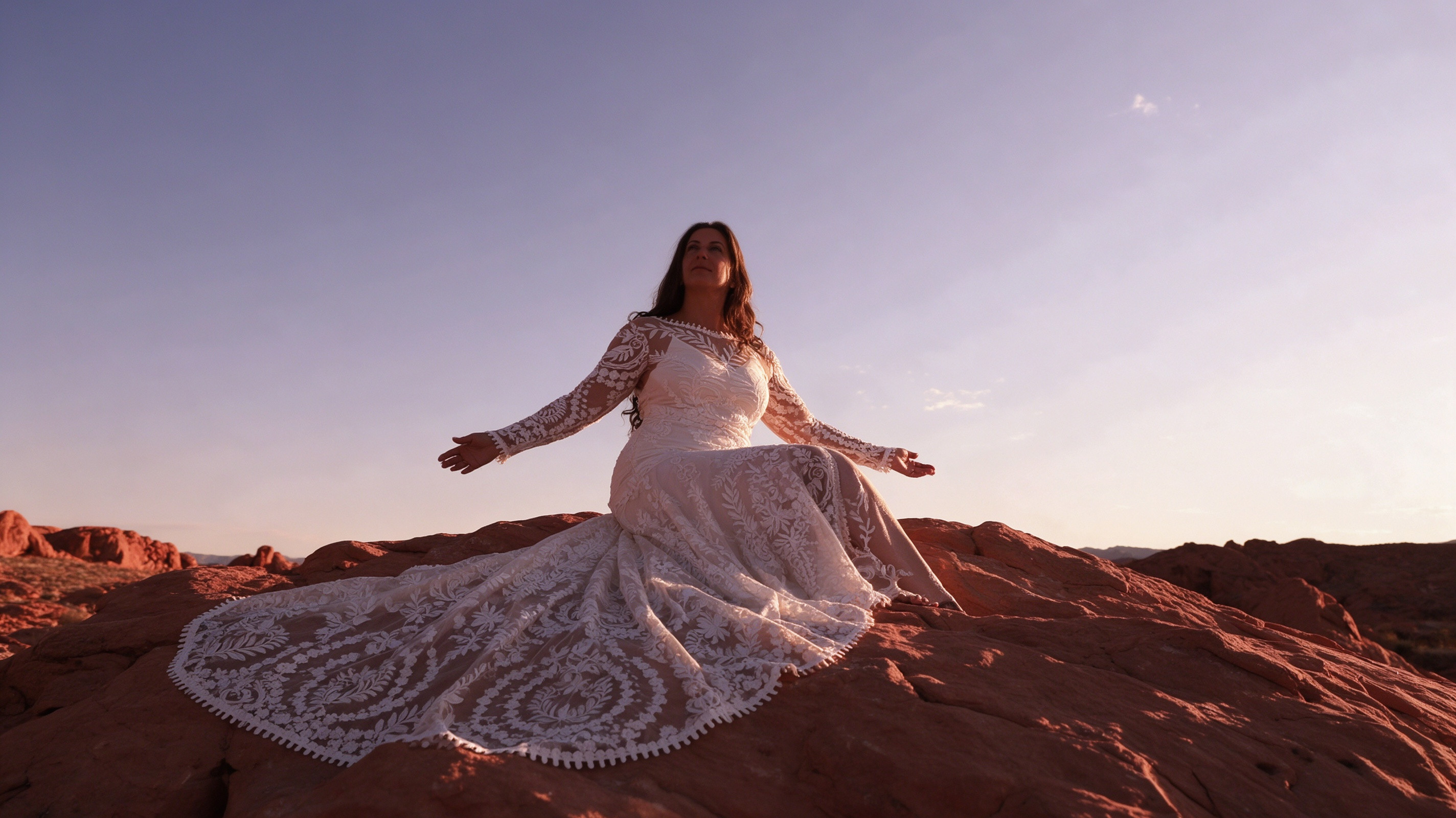 Ivory lace fit and flare wedding dress sitting in a desert canyon