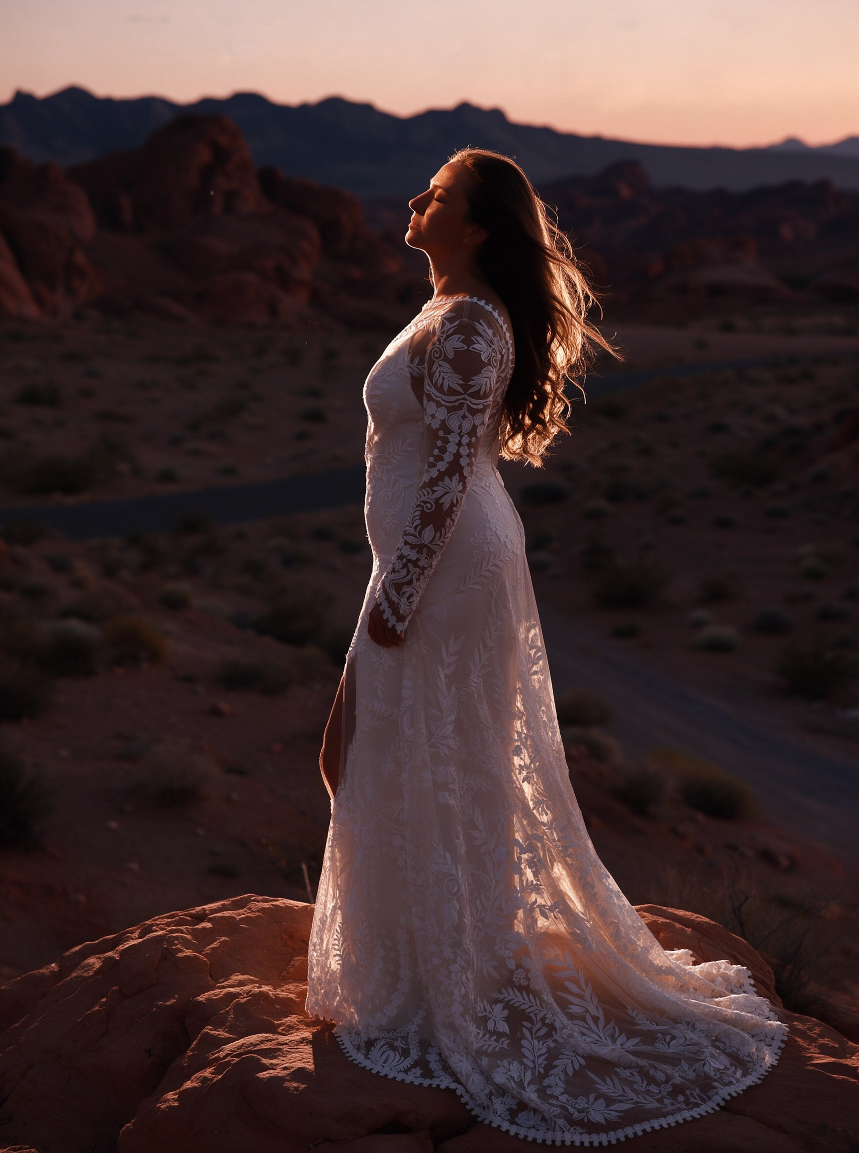 Ivory lace wedding dress train flowing across a desert canyon