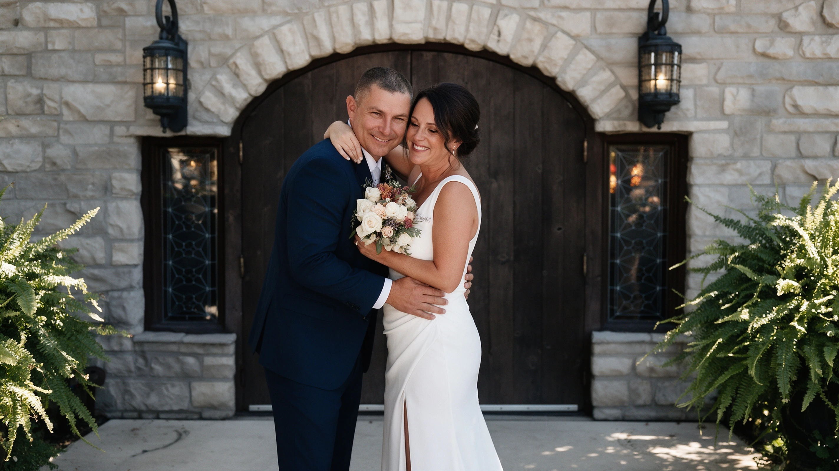 Bride and groom kissing beneath the arched doors at Gideon Owen winery
