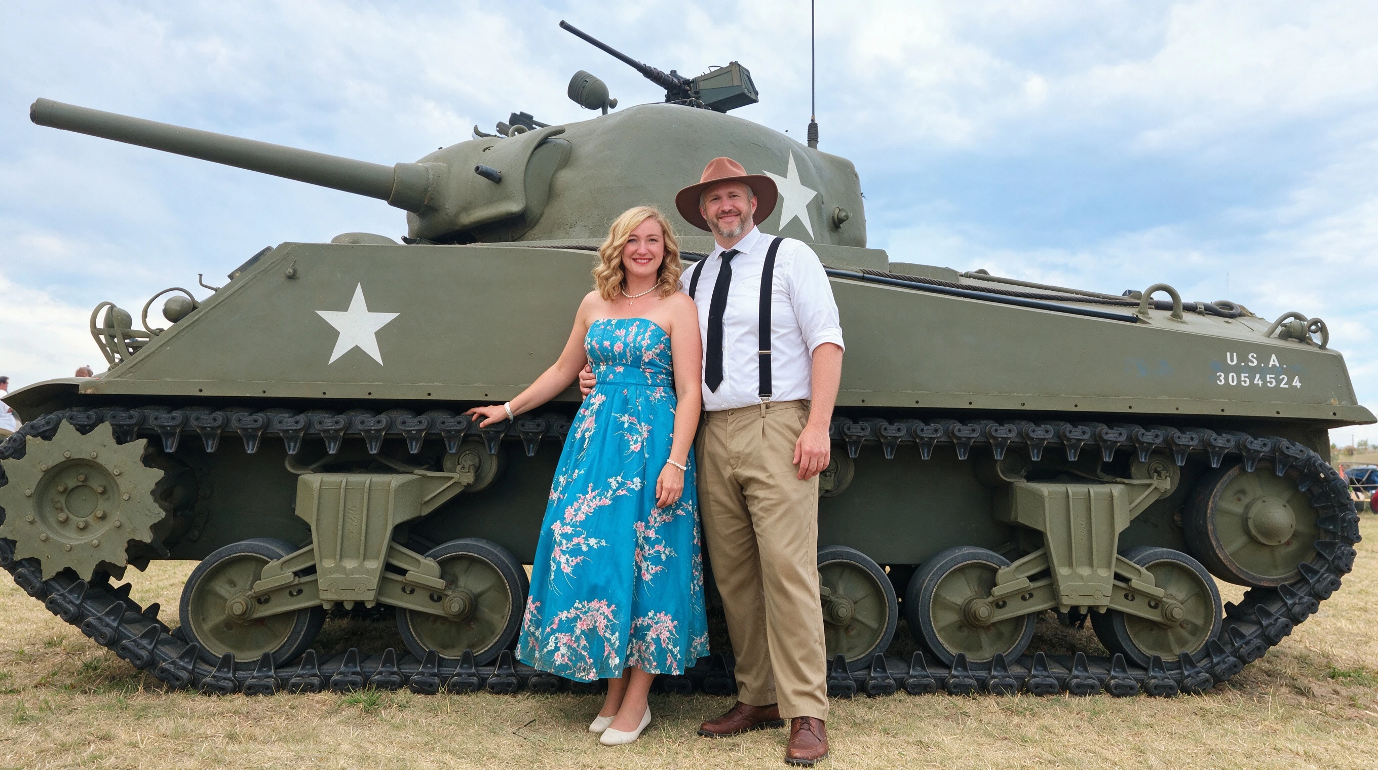 Woman in a cream floral lace A-line dress posing beside a vintage military tank