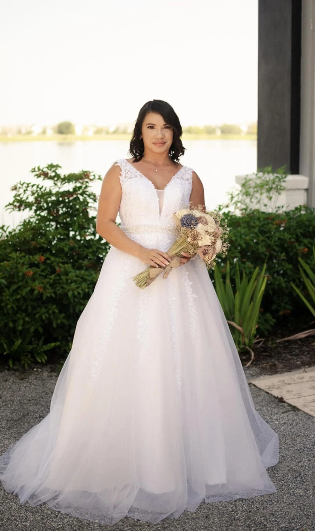 Bride posing beside the lake in a full tulle A-line wedding dress