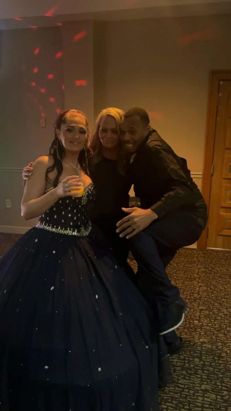 Bride laughing with friends while wearing her navy blue wedding dress