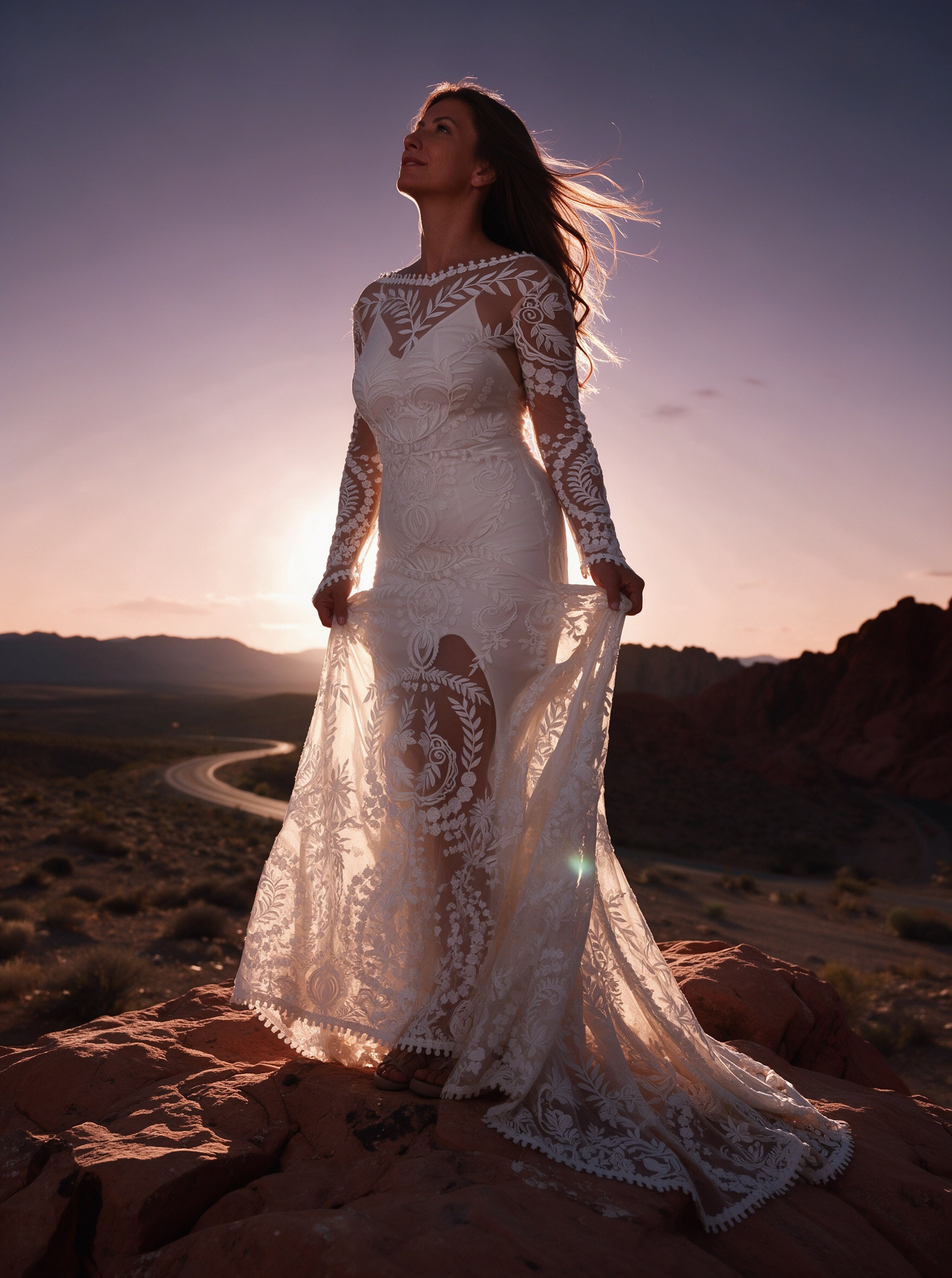 Long sleeve lace bridal dress beside a desert cliff at sunset