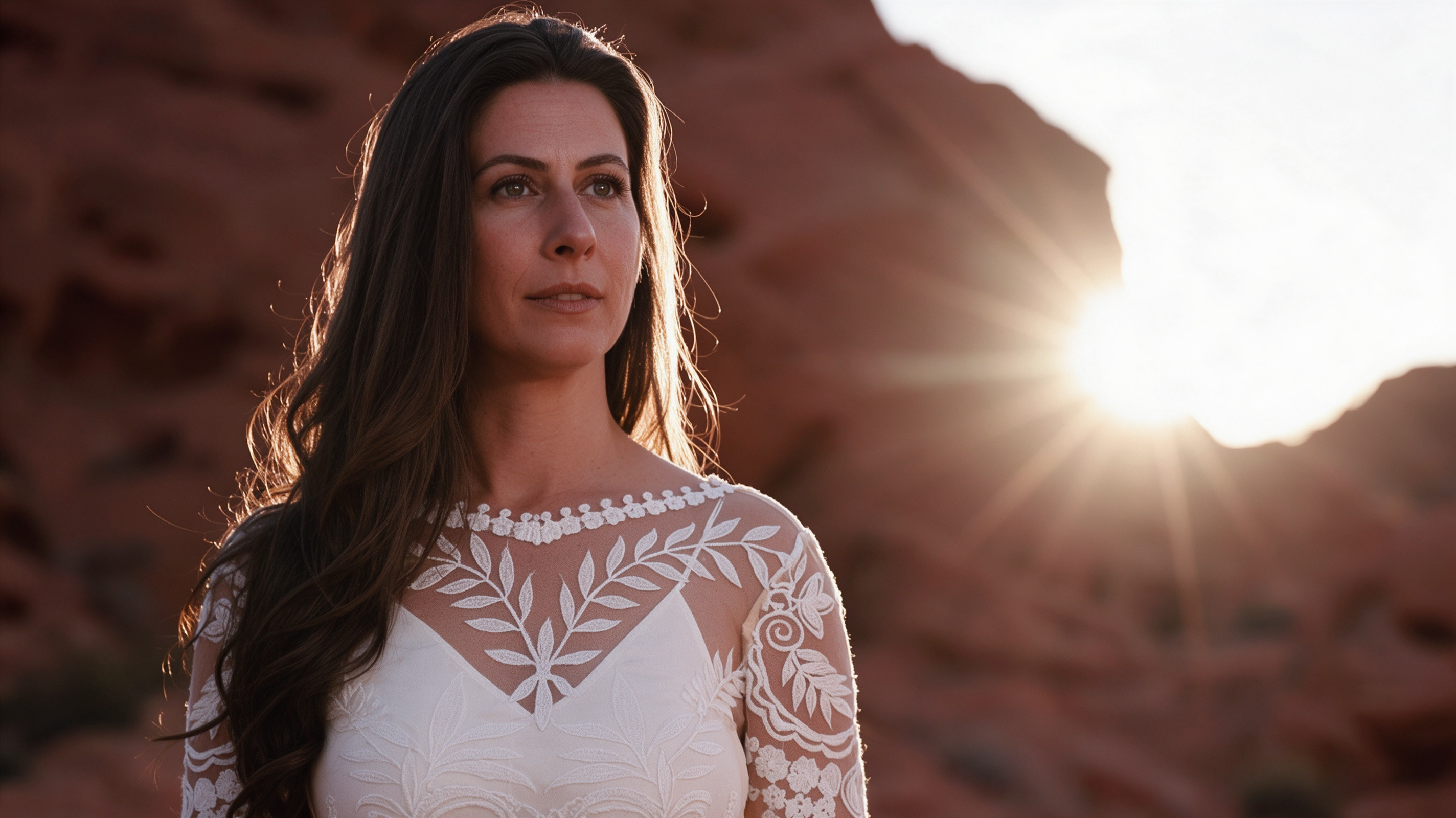 Close up of long sleeve ivory lace wedding dress in golden sunlight