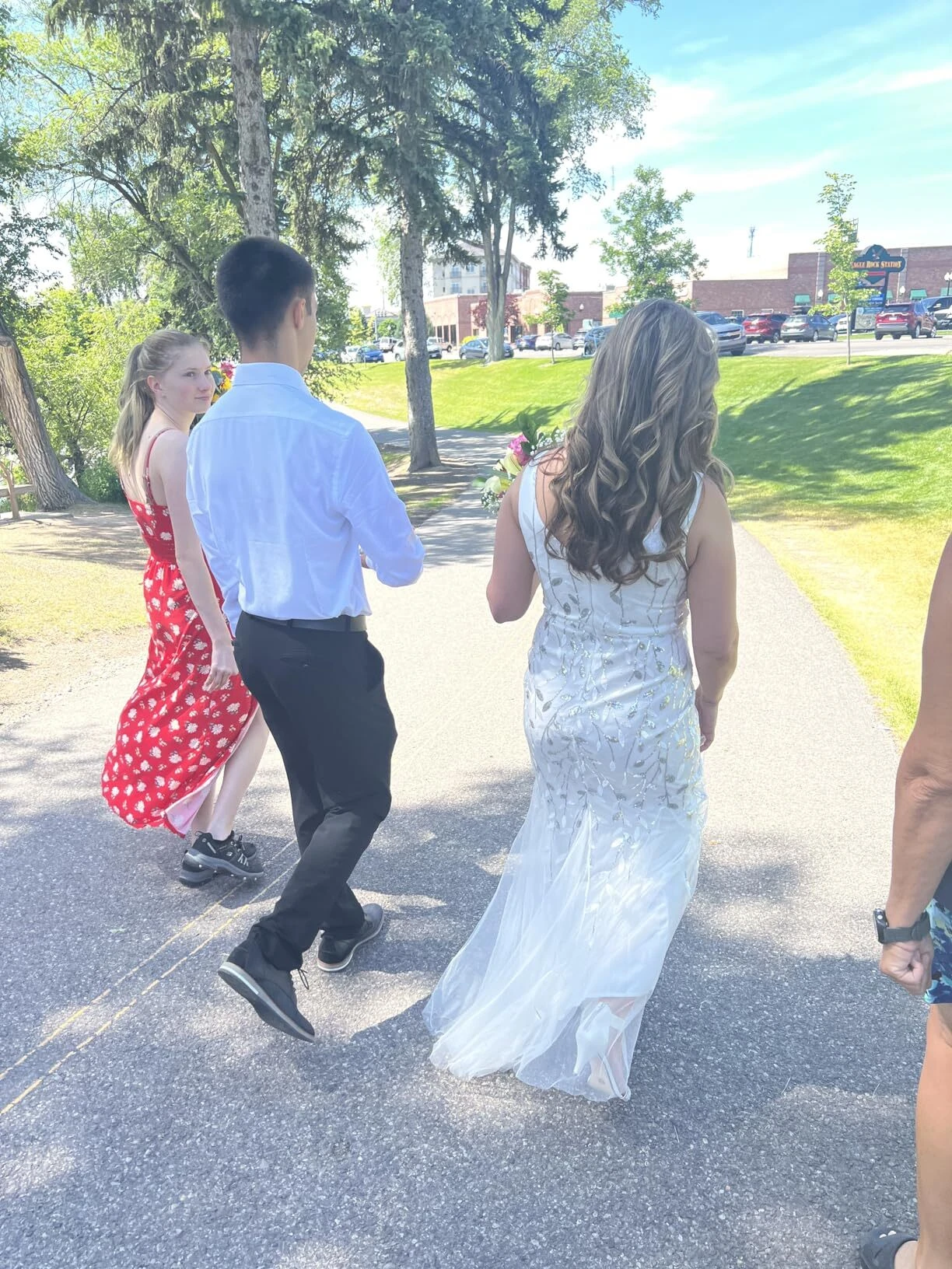 Bride walking down the park trail with her family on the wedding day