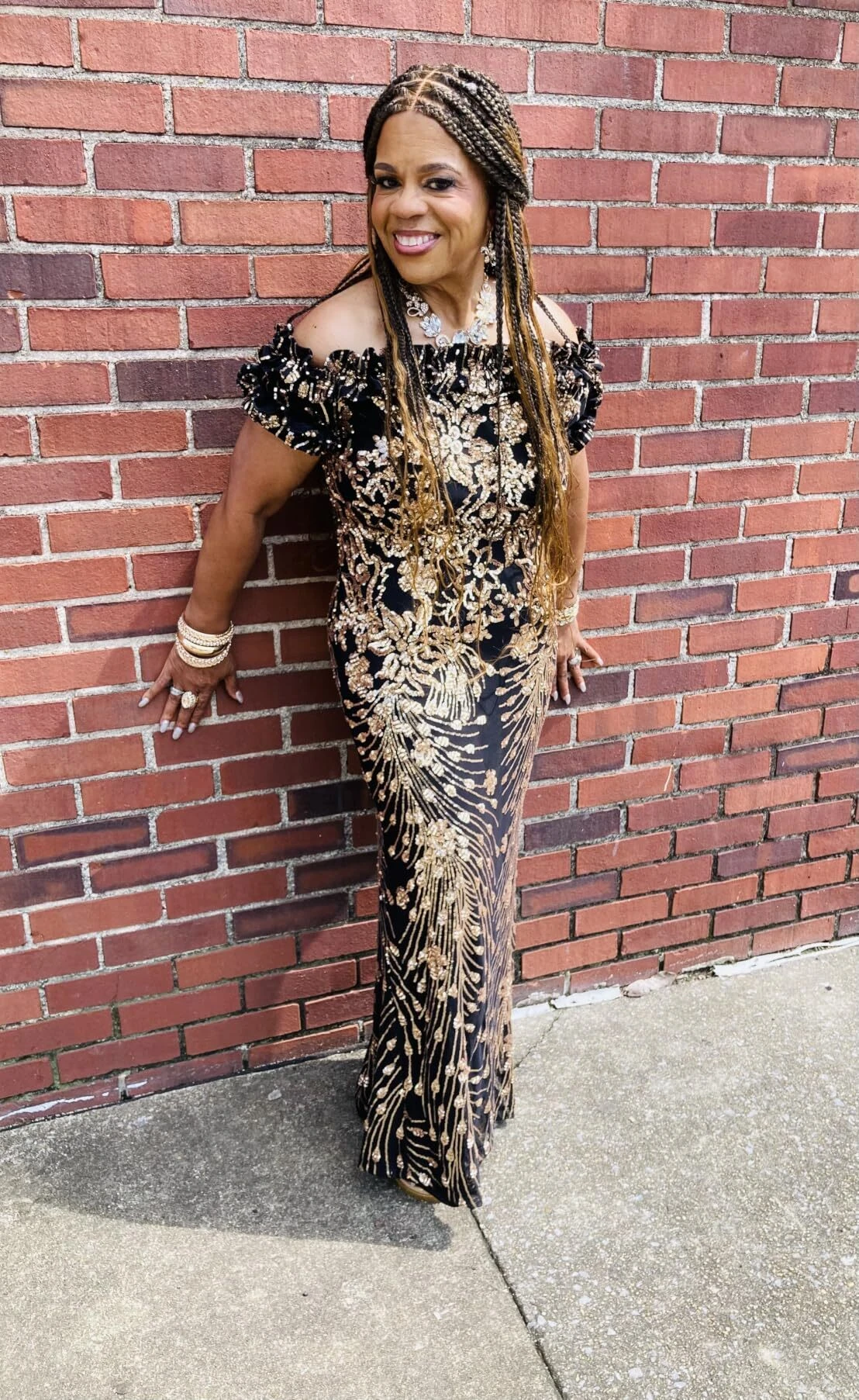 Off shoulder black and gold sequin gown outdoor portrait