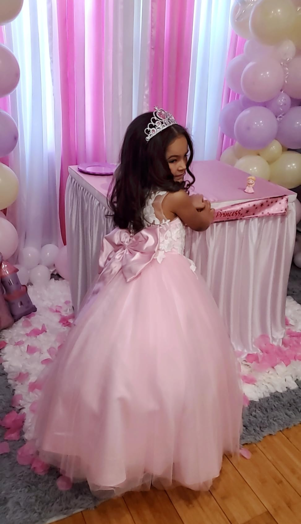 Little girl wearing a pink flower girl dress at a princess birthday