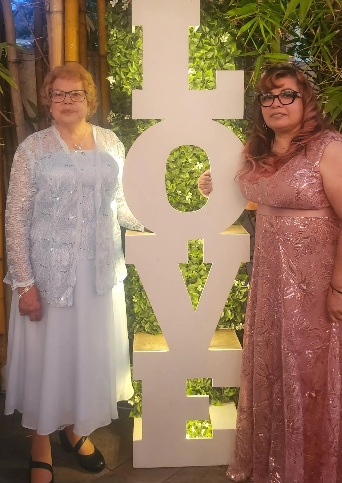 Pink wedding guest dress beside wedding LOVE sign