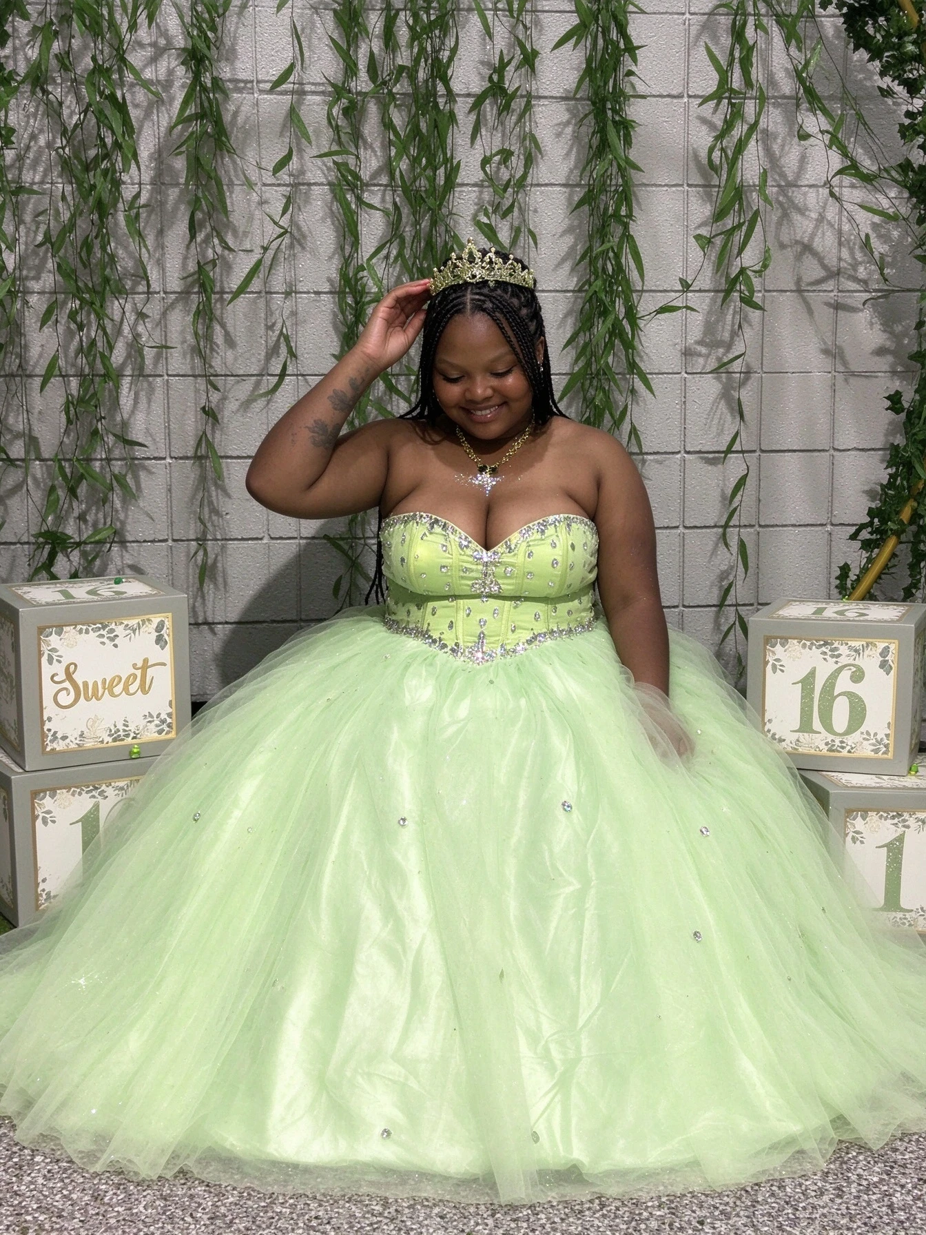 Green quincea&ntilde;era style tulle ball gown accessorized with a gold crown