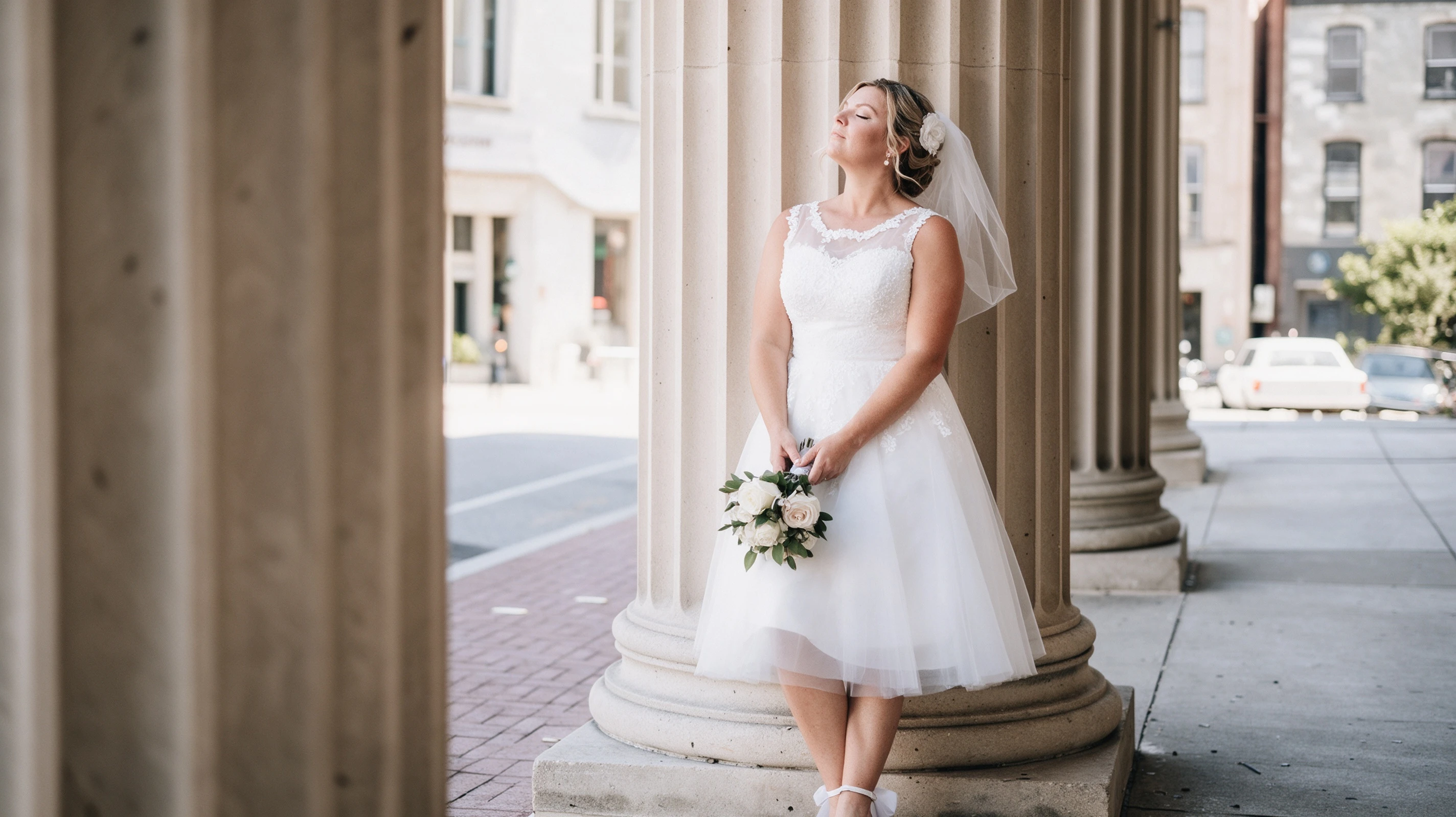 Sitting by columns in my short lace wedding dress