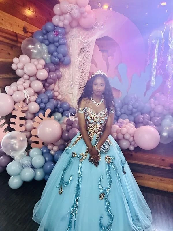 Turquoise ball gown beneath a colorful Under the Sea event arch