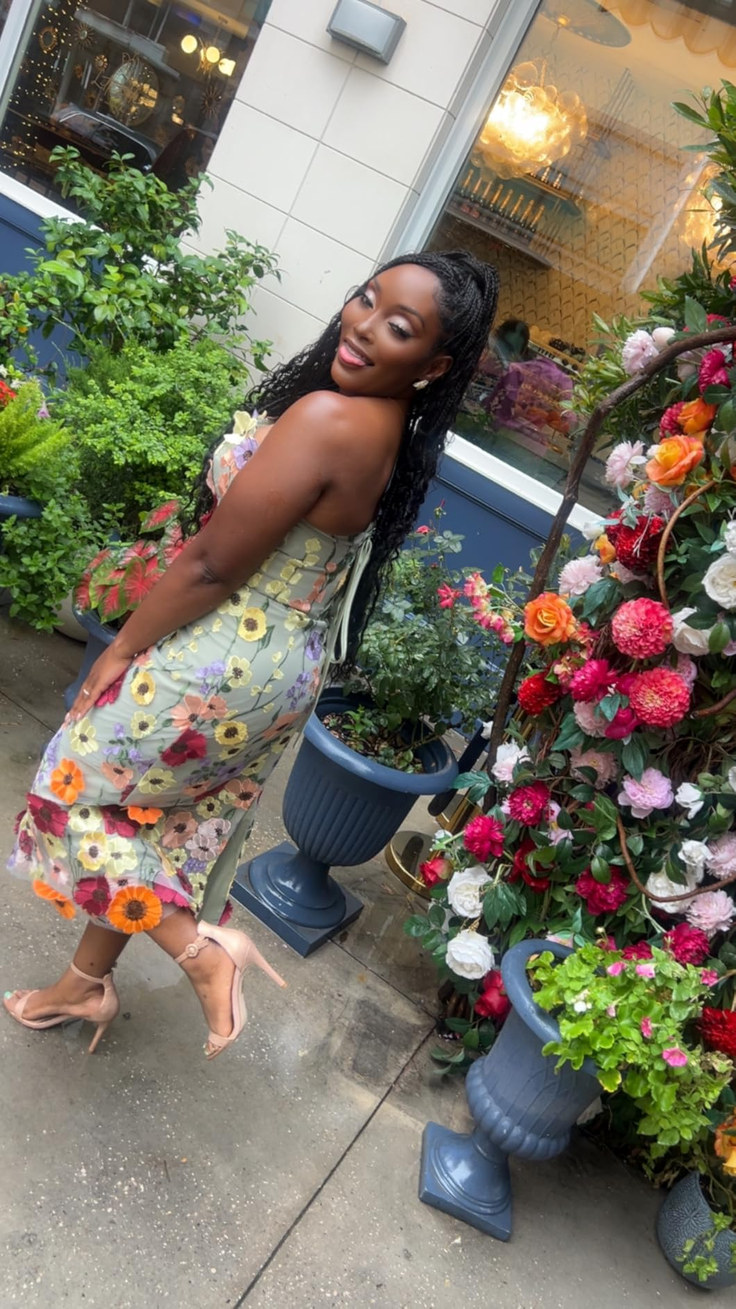 Woman wearing a strapless floral midi dress during a birthday garden portrait session