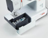 Bernette 35 sewing machine white accessory storage compartment with bobbins and presser feet shown open