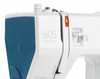 Bernette b05 Academy sewing machine close-up showing blue cover, carrying handle, and white body with tote bag