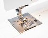Janome Sewist 721 needle plate illuminated by built-in work light, showing clear visibility of the stitching area