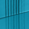 A striking flat-lay showing multiple stitch types sewn on teal fabric, displayed on two slightly different shades. The top portion shows the top cover stitches (with the characteristic lattice pattern visible on both sides), while the bottom shows the reverse side with single chain stitches. Excellent for a stitch comparison or feature callout graphic.