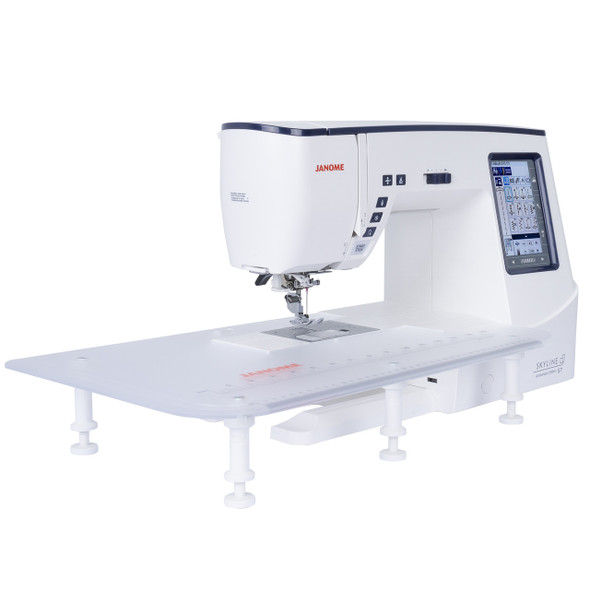 Janome Skyline S7 Anniversary Edition shown from the side with extra-wide extension table attached, displaying the full quilting workspace