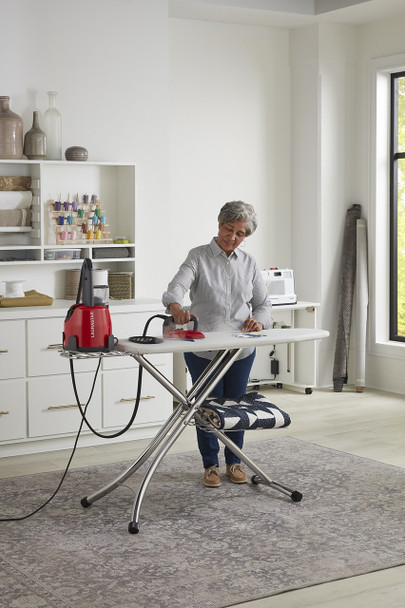 Lady using the Laurastar Lift Red to steam clothes on an ironing board
