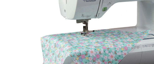 Close-up of Brother PS500 presser foot sewing pastel floral fabric showing stitch quality