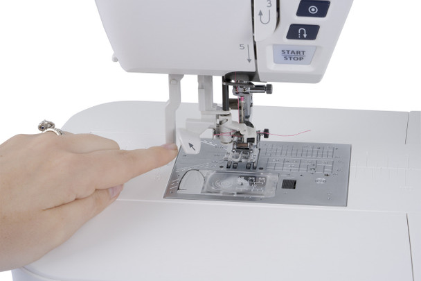 Close-up of the Janome Skyline S7 Anniversary Edition needle plate showing the 9mm stitch width markings, feed dog, and needle drop position guides