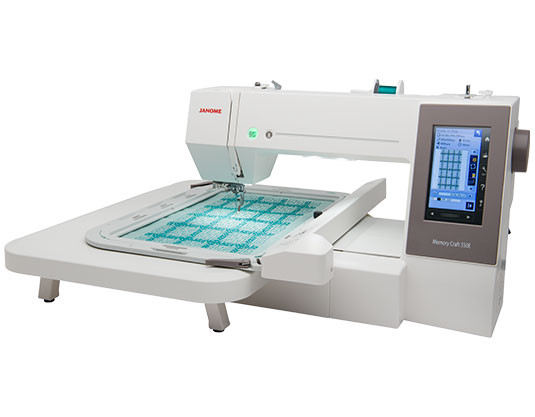 Janome 550e embroidery machine from a second side angle, showing the arm, hoop attachment area, and machine profile