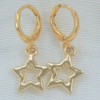 Close-up of gold open star charm huggie hoop